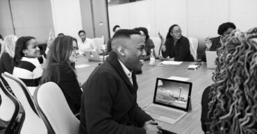 group of people sitting in conference table laughing | SMART Goals